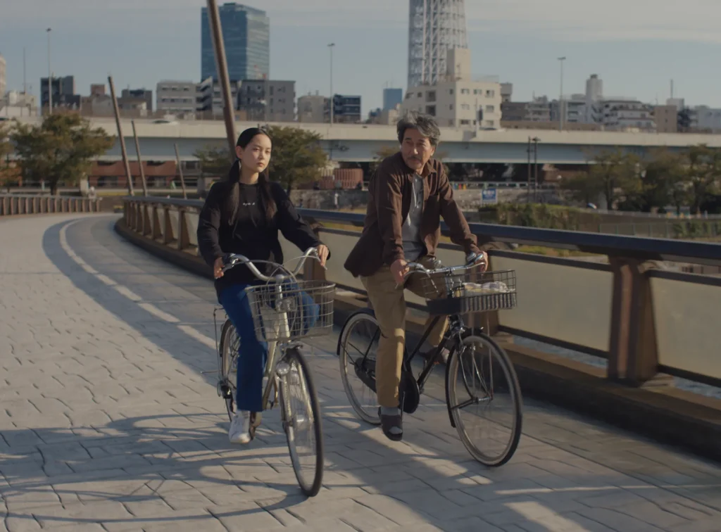 A man and a girl riding their bikes in the daytime